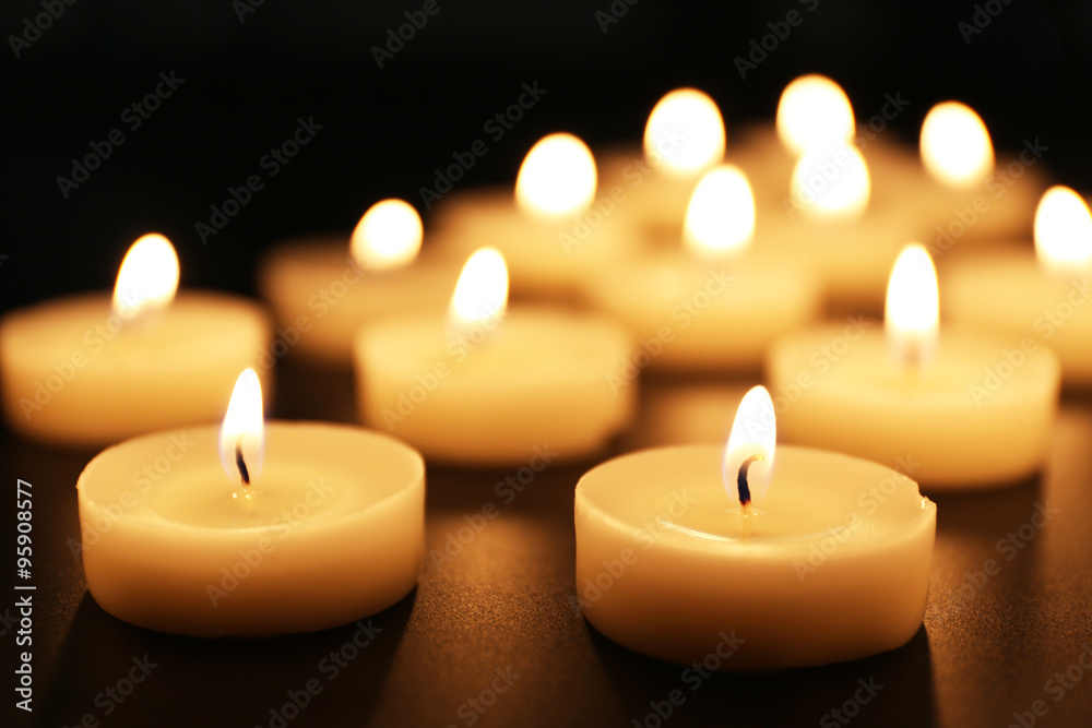 Alight candles in a row on black background Alight candles in a row on black background