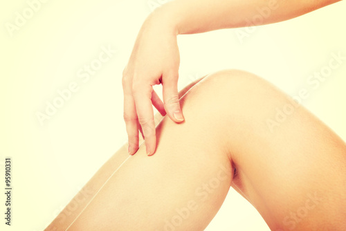 Woman touching her leg.