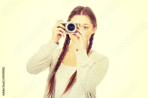 Teen woman making photo with camera.