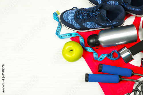 Sport clothes, shoes and sport equipment on light background