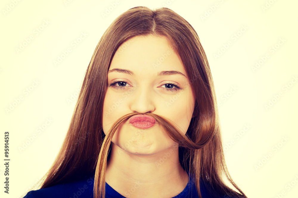 Teenager making moustache from hair. Teenager making moustache from hair.