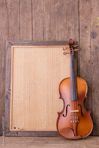 violin in vintage style on wood background © ittipol