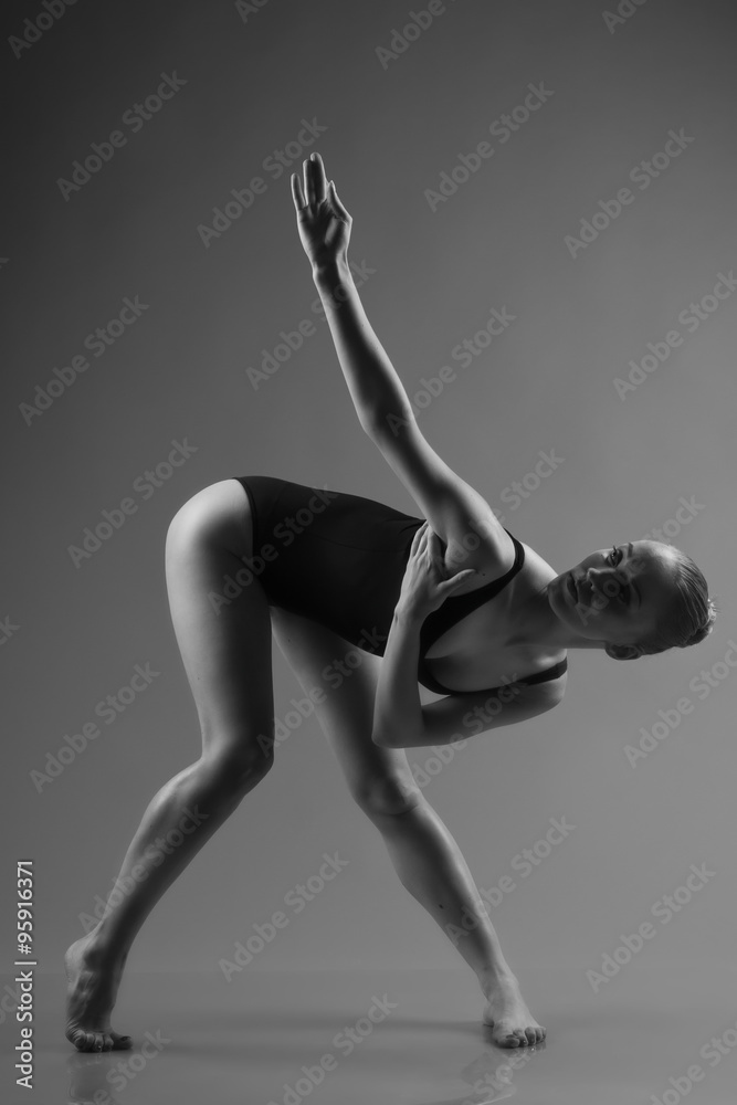 Obraz premium Modern ballet dancer posing on dark background