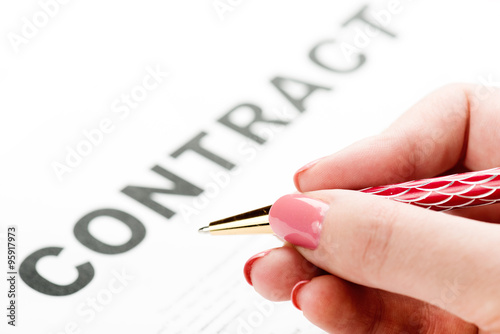 Businesswoman's hand with pen signing a contract.
