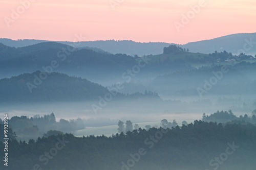 Misty morning. Autumn fog and clouds above freeze mountain valley, hilly landscape