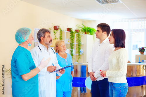 worried relatives listen to medical staff about news from difficult surgery after misadventure