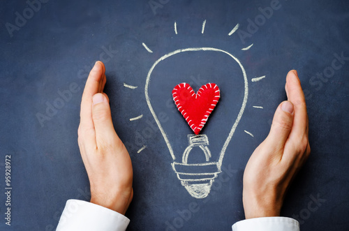 male hands involves drawing light bulb on chalkboard