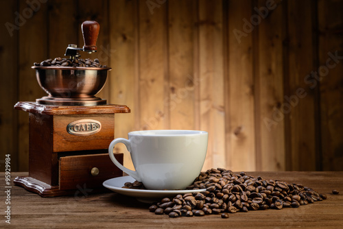 still life with coffee beans and old coffee mill on the wooden background