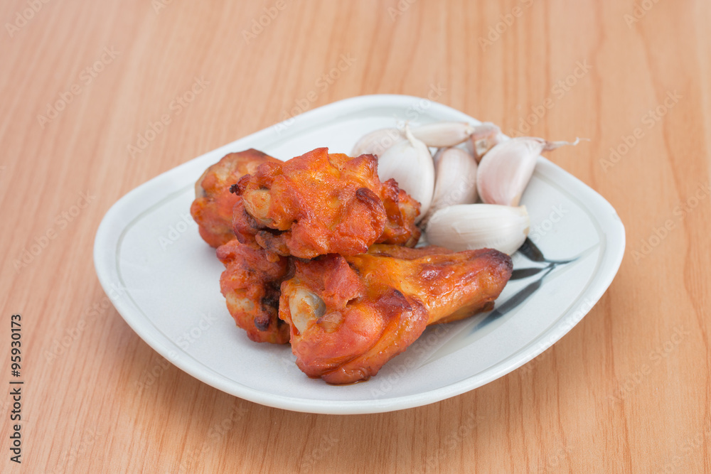 Chicken wings in dish on wooden table. Chicken wings in dish on wooden table.