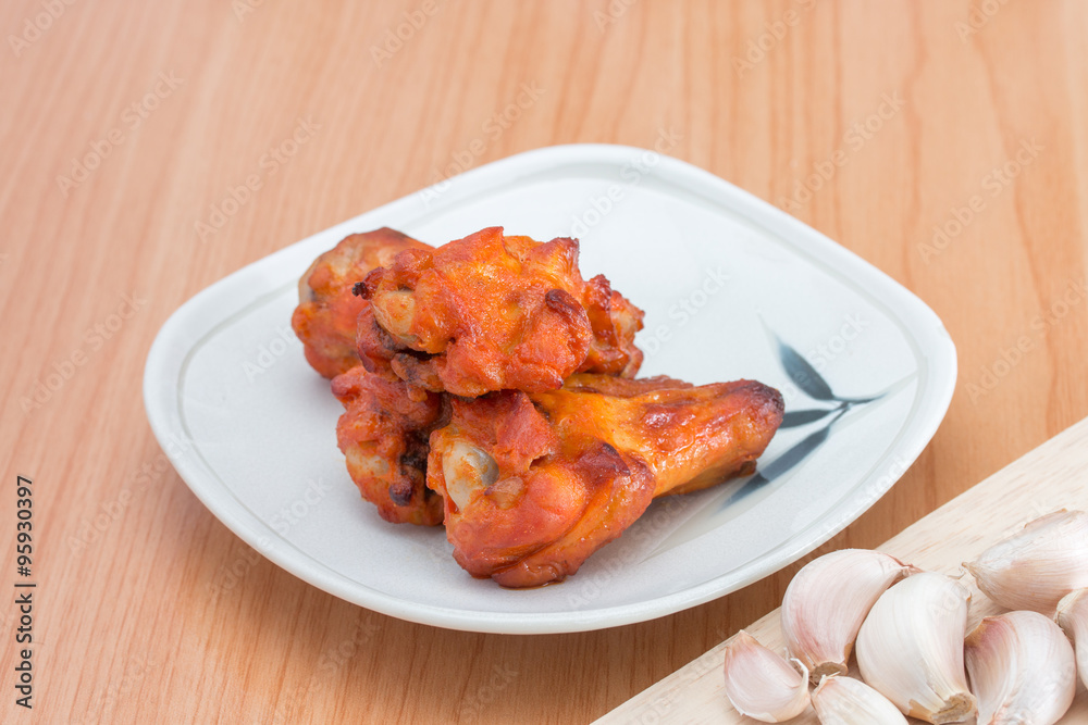 Chicken wings in dish on wooden table. Chicken wings in dish on wooden table.