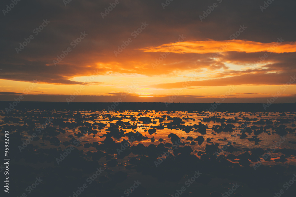 Obraz premium Sunset on beach in Iceland with volcanic rocks and beautiful clouds