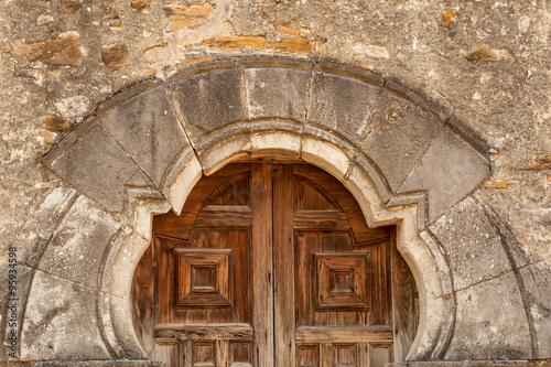 Close up of the San Espada Mission Church Doors / detail of the old mission church door against Worn Stone Wall