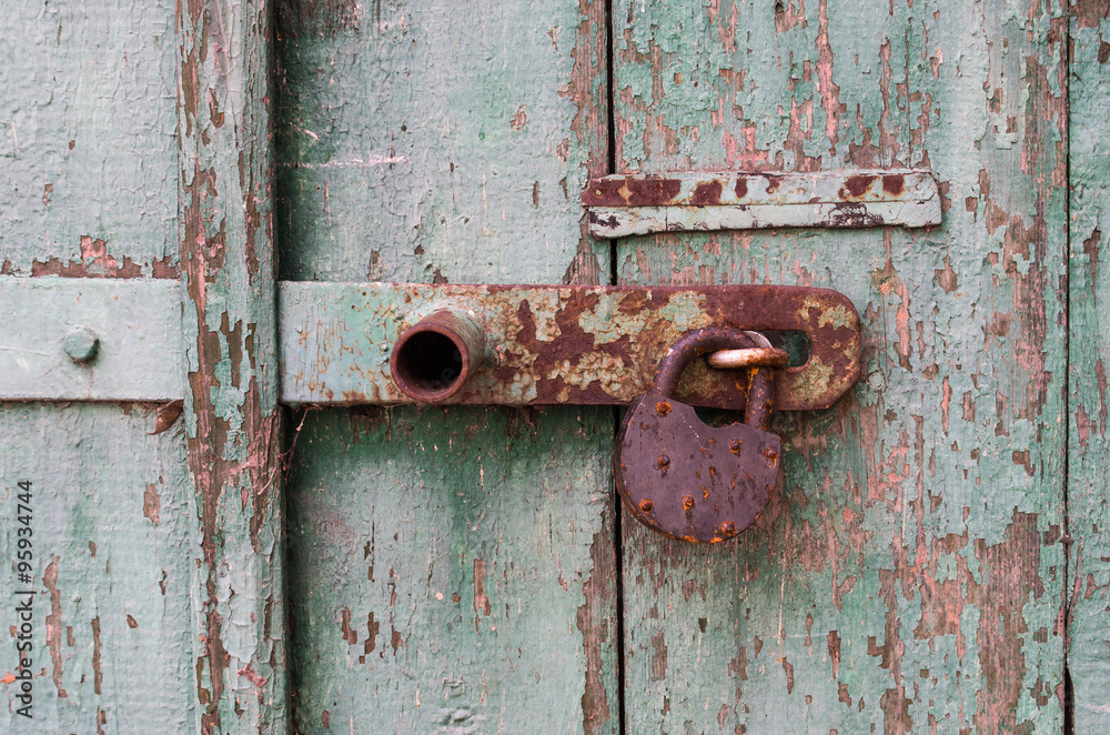 Detail of old wooden door with rusty padlock Detail of old wooden door with rusty padlock