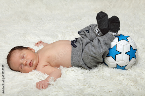 Śpiące niemowlę z piłką, noworodek.