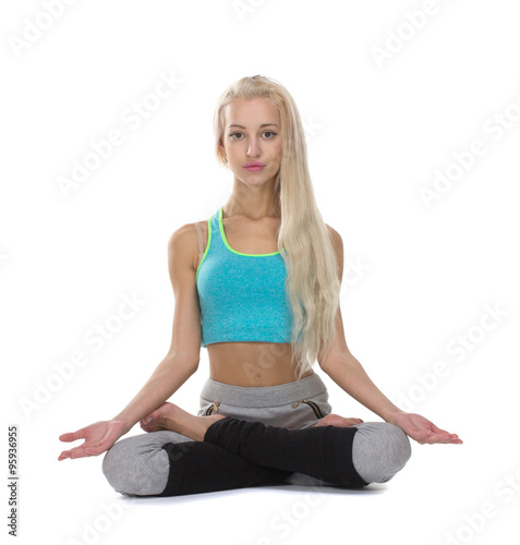 Portrait of young woman meditating in pose of lotus in isolation