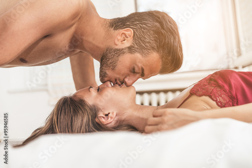 Lovers kissing in bed