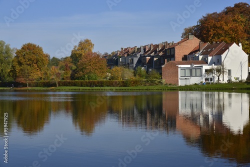 Reflet de la nature automnale et des maisons dans le grand étang de la Hulpe
