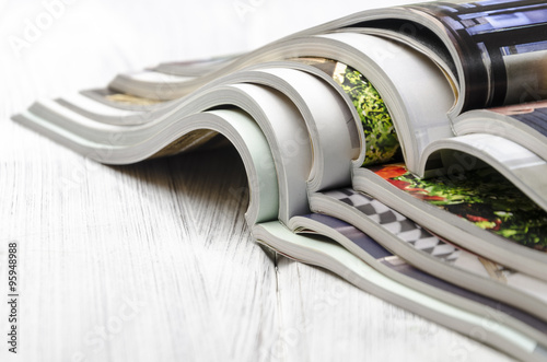 stack of magazines on a white wooden background photo