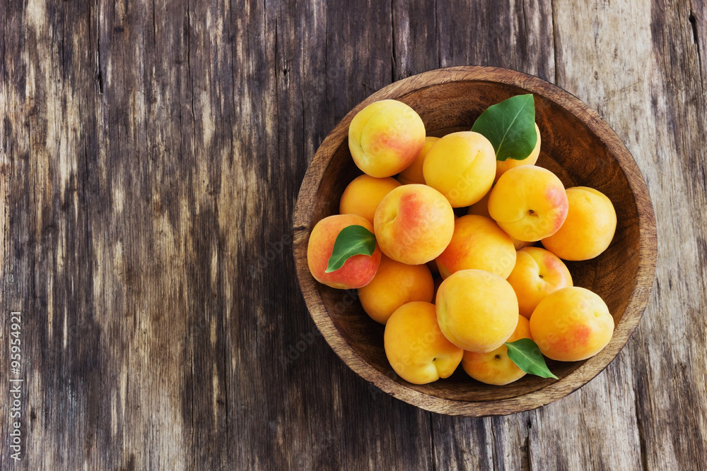 ripe apricots in a wooden bowl
