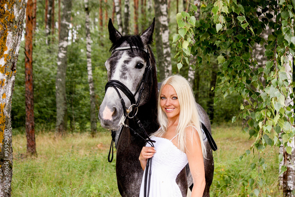 Obraz premium Beautiful blonde woman and gray horse in forest