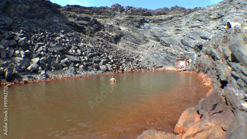 Tourists bathe in the hot volcanic springs. Palea Kameni island, Greece.
 photo