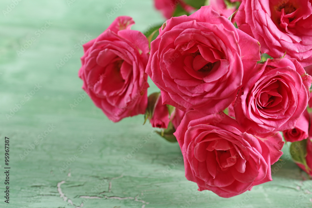 Naklejka premium Beautiful roses on wooden background