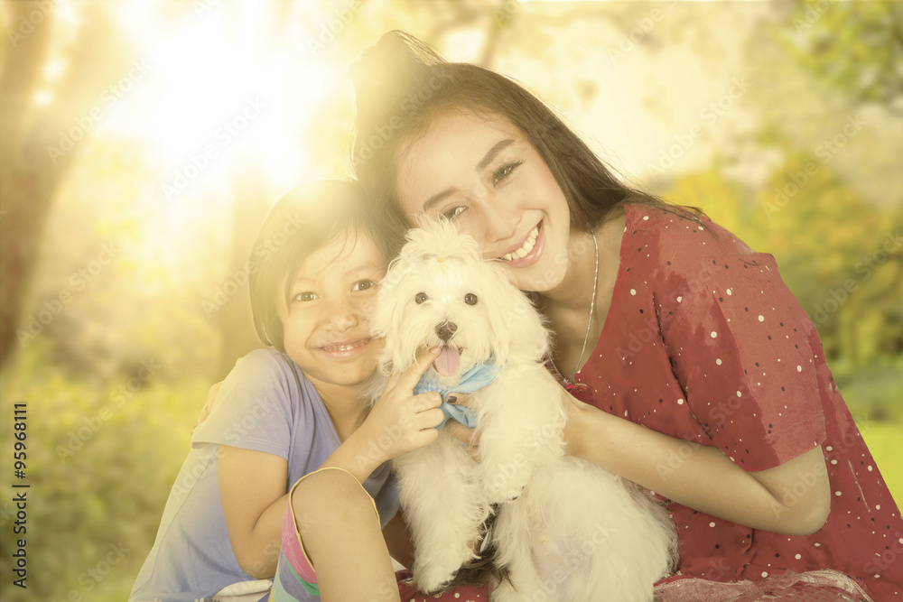 Little girl with her mom and dog at the park Little girl with her mom and dog at the park