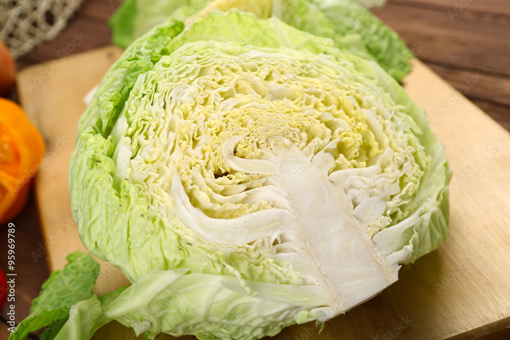 Cut savoy cabbage and pepper on wooden cutting board closeup Cut savoy cabbage and pepper on wooden cutting board closeup