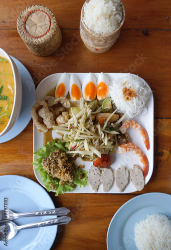 Spicy papaya salad serving with shrimp, boiled egg, porkball and photo