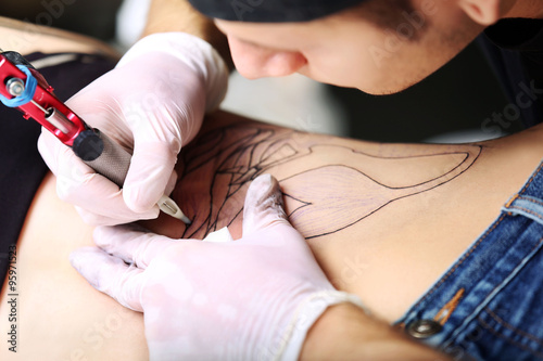 Tattooist makes tattoo, clo...