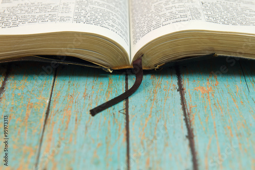 Opened Bible with a bookmark on Wood photo