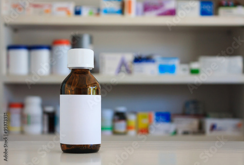 Blank white label of medicine bottle with blur shelves of drug i