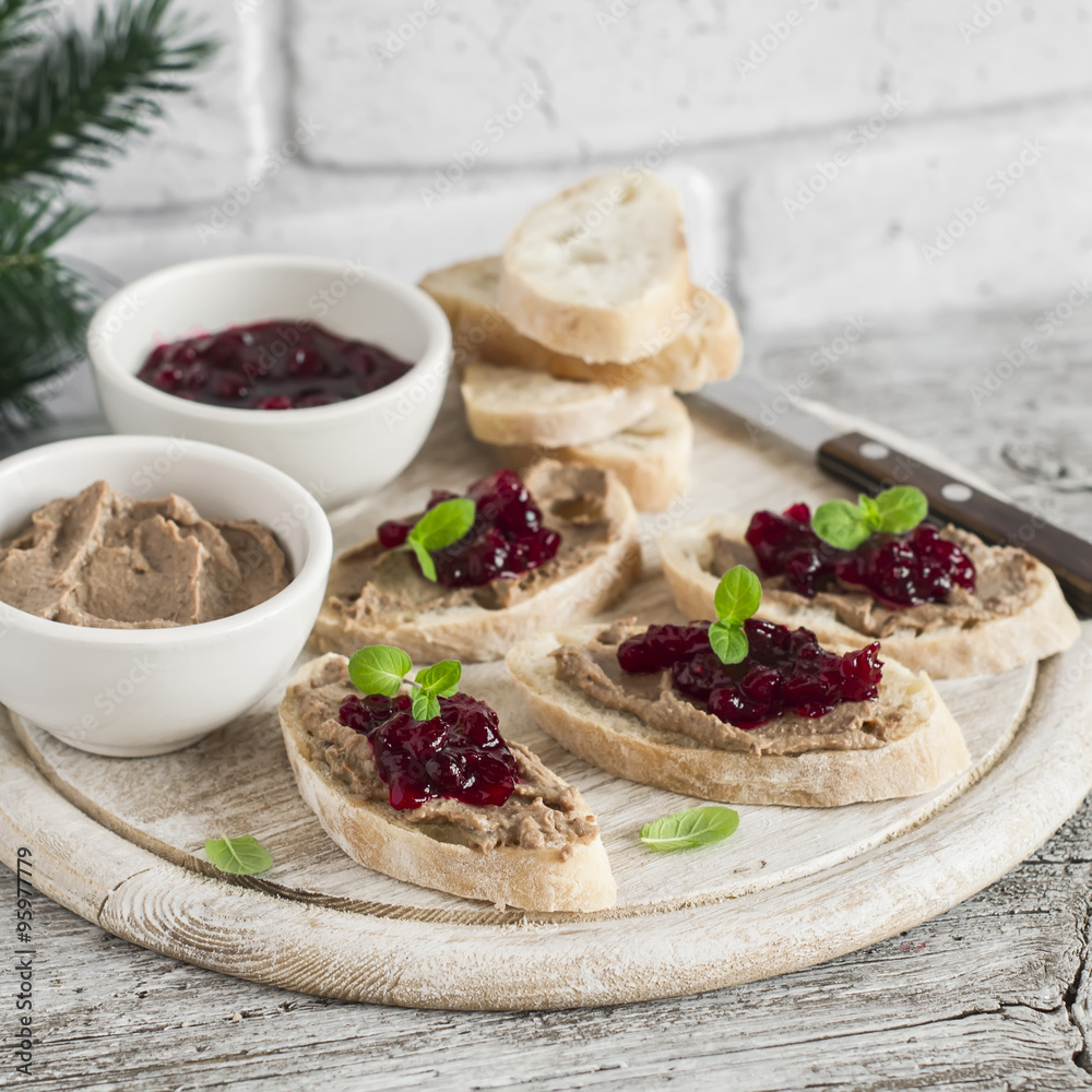 Sandwiches with chicken liver pate and cranberry sauce, served on a light wooden board Sandwiches with chicken liver pate and cranberry sauce, served on a light wooden board