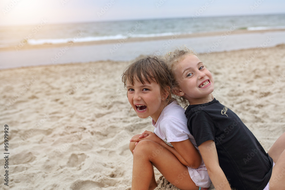 Two young friends girls laughing on the beach Two young friends girls laughing on the beach