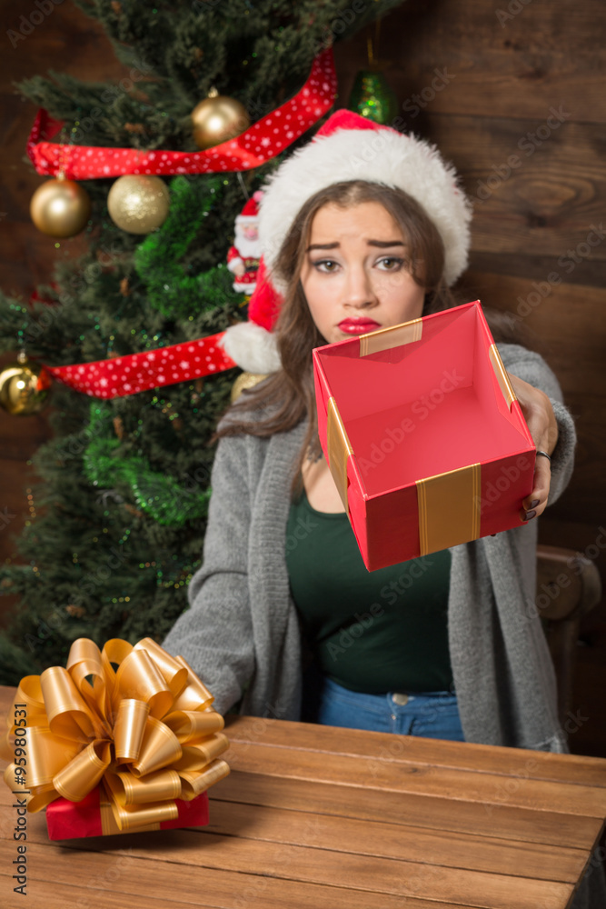 Beautiful girl demonstrating empty box of present near New Year tree Beautiful girl demonstrating empty box of present near New Year tree