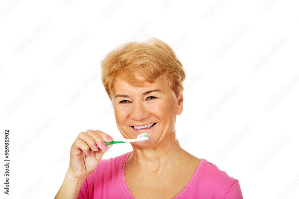 Smiling senior woman brushing teeth Smiling senior woman brushing teeth