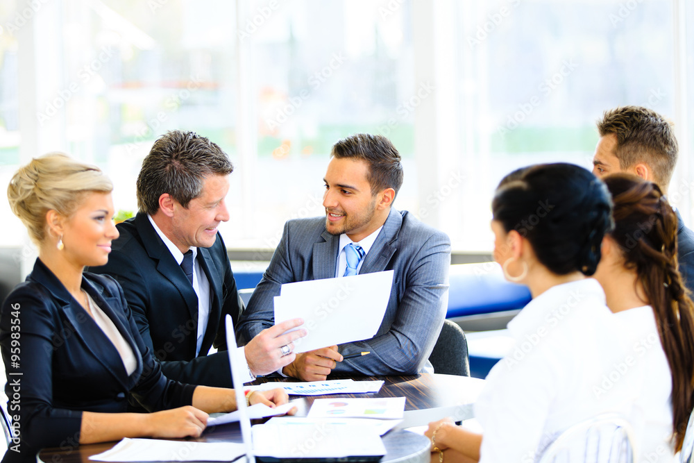 Image of business partners discussing documents and ideas at meeting Image of business partners discussing documents and ideas at meeting