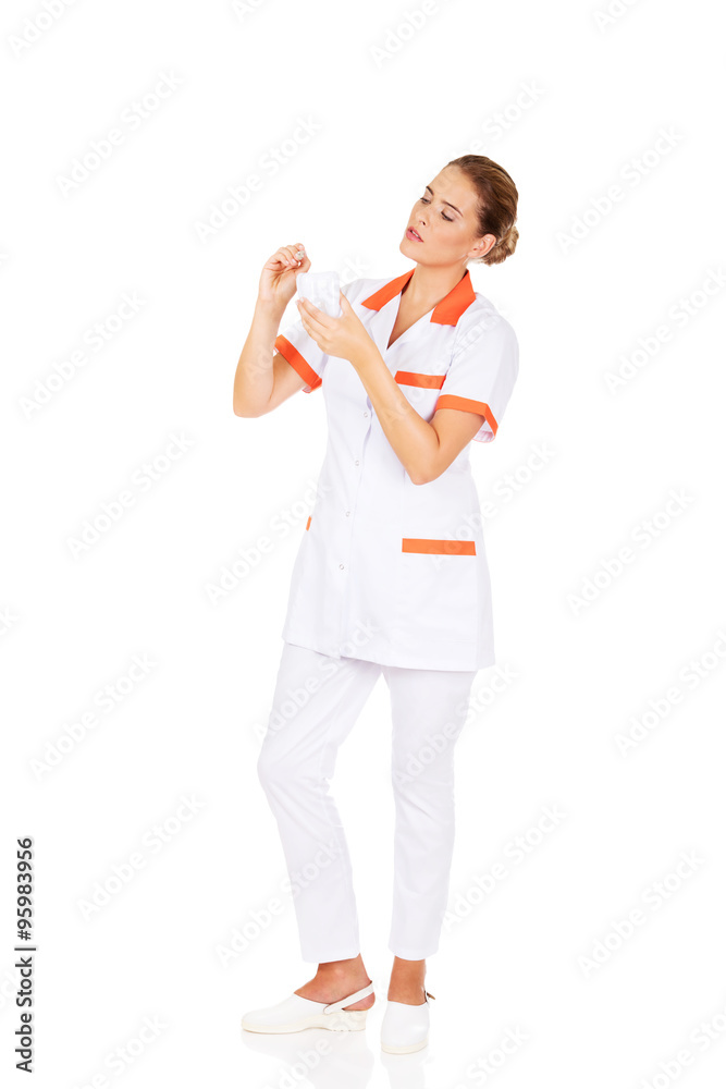 Young female dentist holding a tooth model and dental mirror Young female dentist holding a tooth model and dental mirror