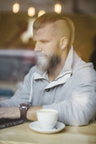 handsome bearded man working in coffee shop