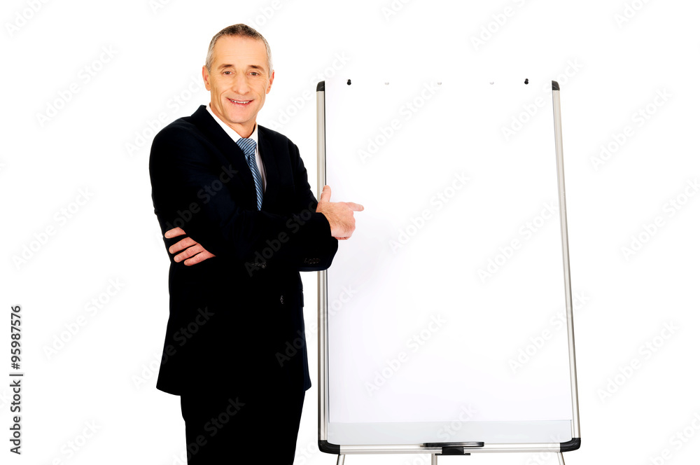 Male executive pointing on flip chart