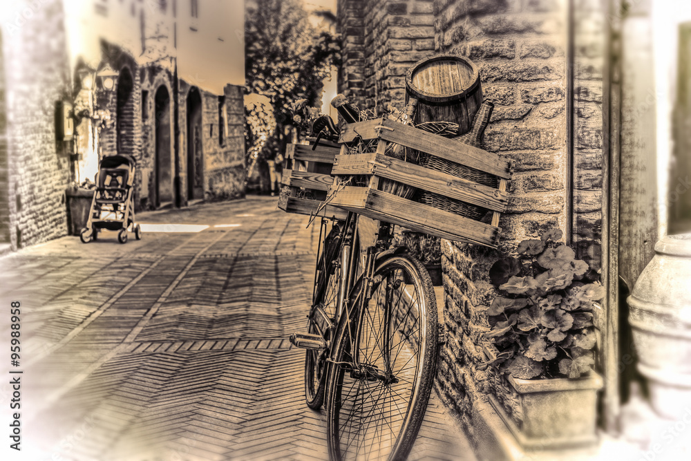 old bike with wooden case against a brick wall in sepia tone