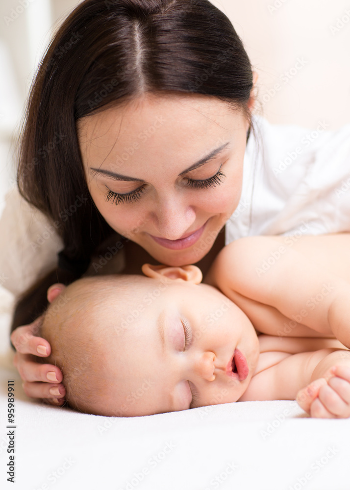 Happy mother looking at sleeping baby Happy mother looking at sleeping baby