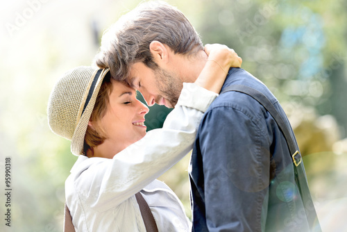 Romantic young couple embracing in park, sunlight