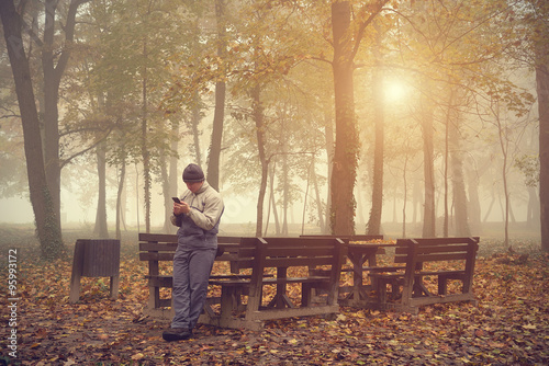 Man play in his mobile phone in the park