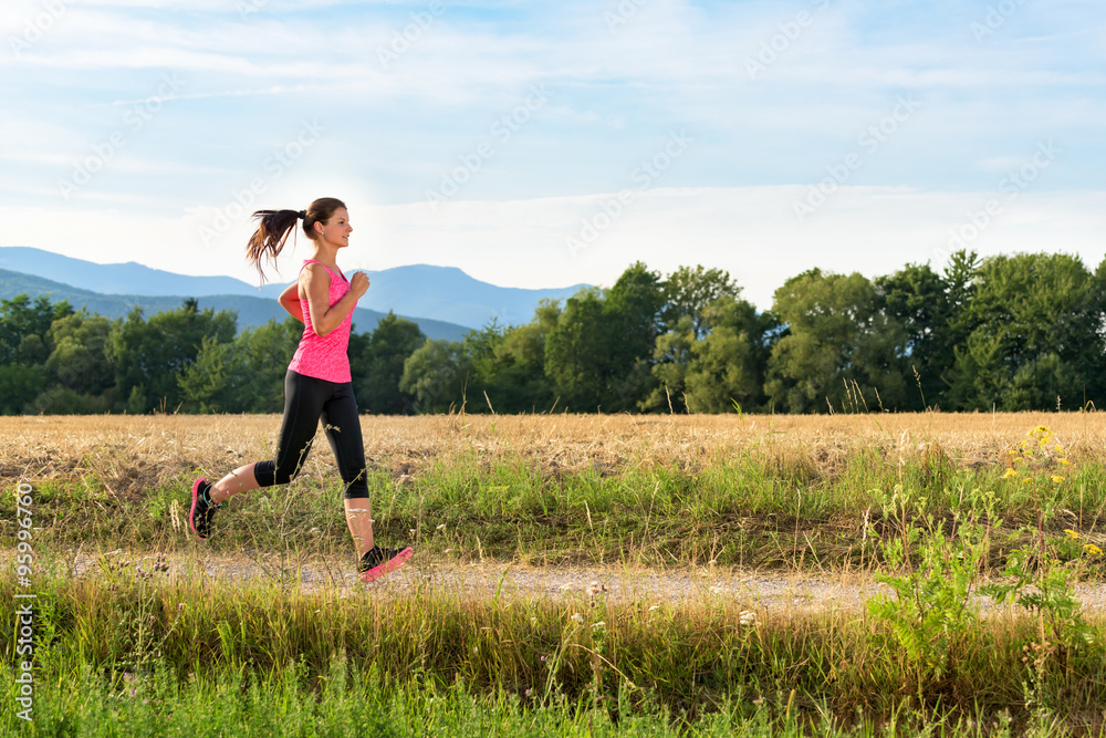 Attractive young female jogging in countryside