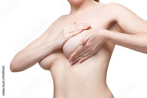 Examining breasts. Close-up of young shirtless woman examining her breasts while. Isolated white background