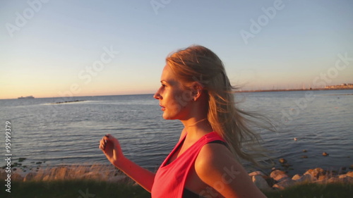 caucasian woman power walking along the ocean at sunset. Good for concepts such as power walking, healthy living and workout