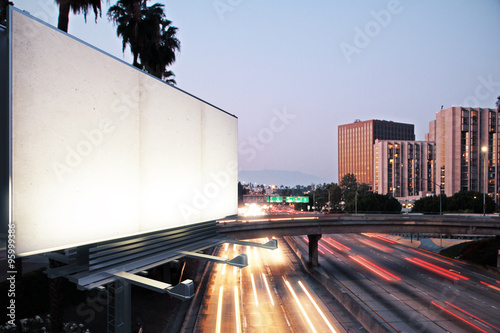 Blank white billboard on the background of the highway at evenin photo