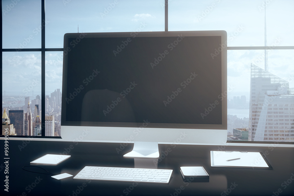 Fototapeta premium Blank computer monitor with office accessories on a table in the