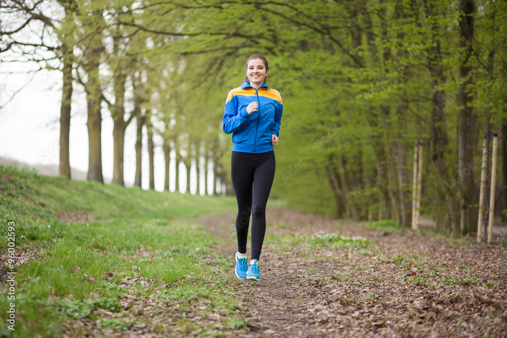 Young beautiful woman running on a trail Young beautiful woman running on a trail